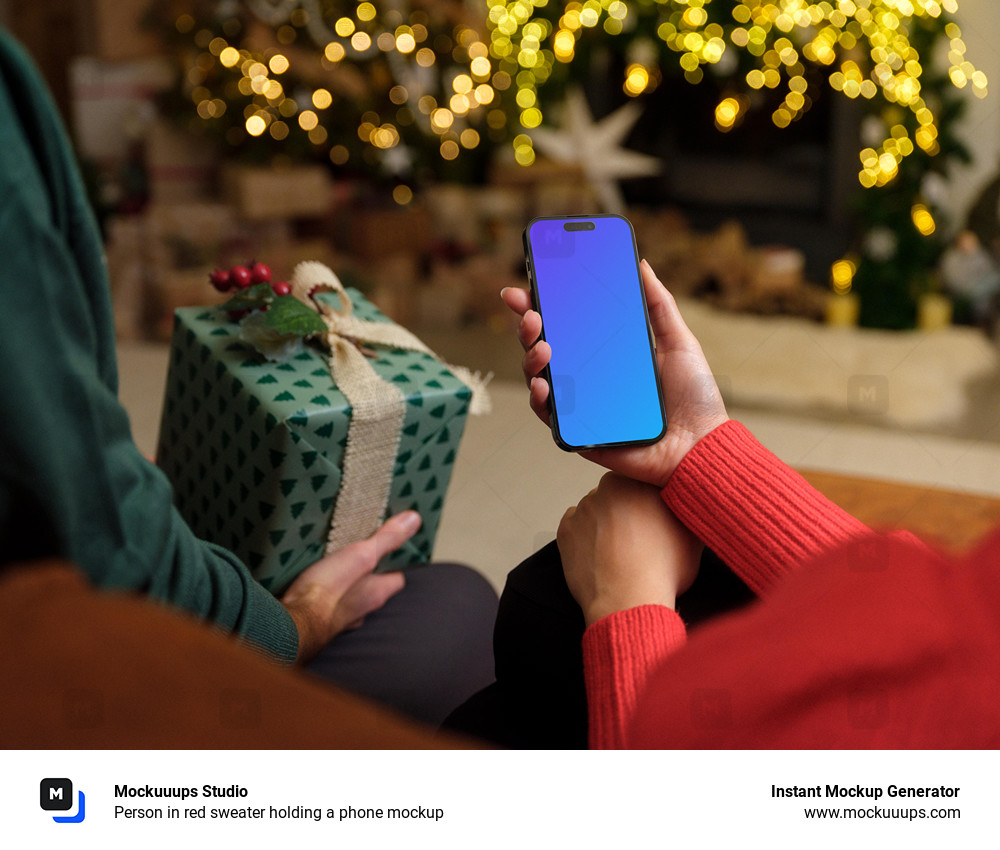 Person in red sweater holding a phone mockup