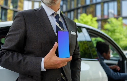 Businessman standing next to the Tesla and holding a phone mockup