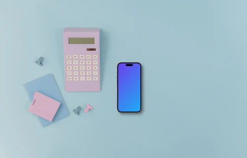 Calculator, small notebook and an iPhone on blue background