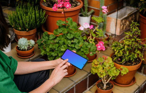 Female hand typing on a Google Pixel mockup in garden