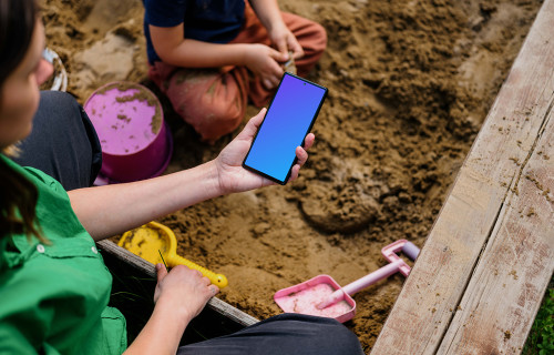 Female holding a Google Pixel in sandpit mockup