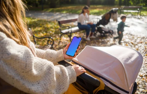 Female holding an iPhone in the park mockup