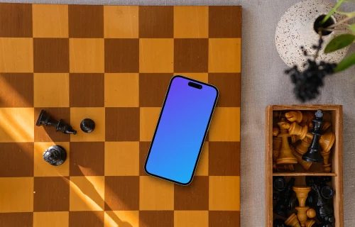 iPhone mockup laying on the chess board