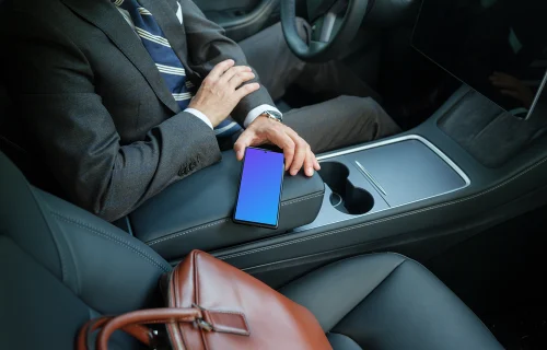 Male entrepreneur in Tesla holding a phone