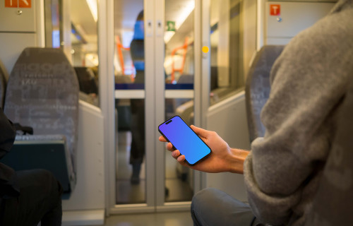 Pasajero con su smartphone en el tren mockup