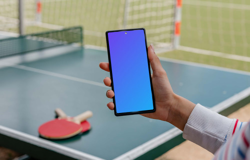 Ping-pong player holding a phone mockup