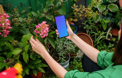Woman holding a Google Pixel in garden mockup