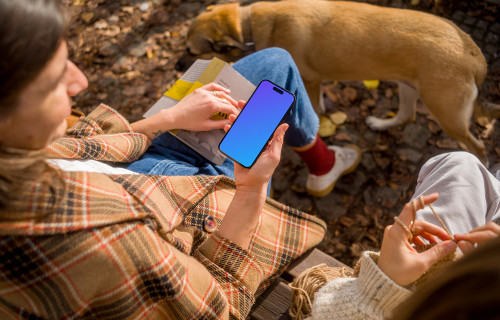 Woman holding an iPhone 14 near dog mockup