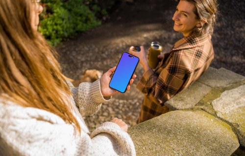 Woman holding an iPhone 14 Pro next to the friend mockup