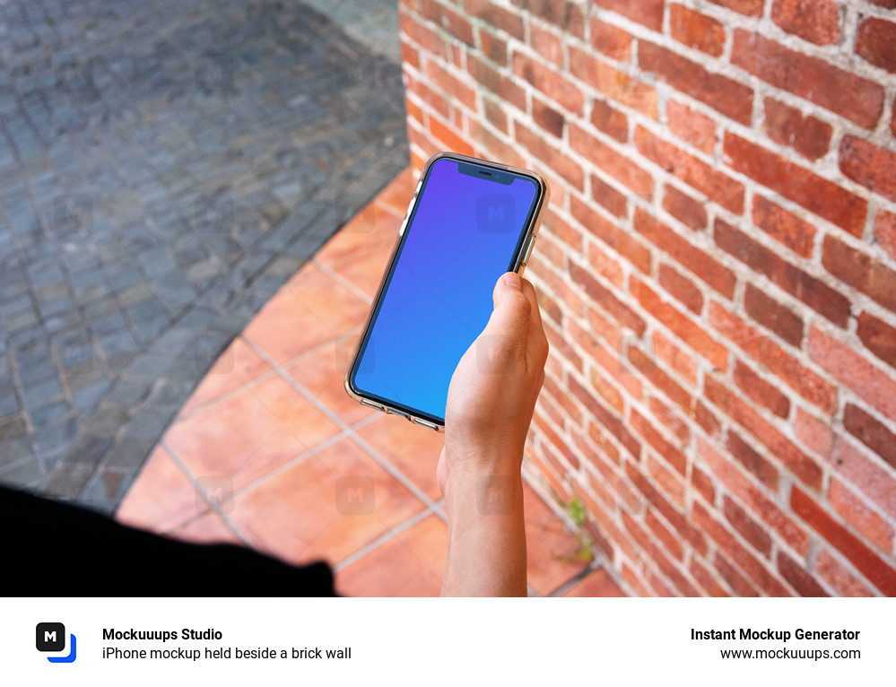 iPhone mockup held beside a brick wall