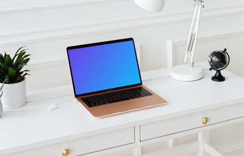 MacBook Air mockup on a white table beside a potted plant