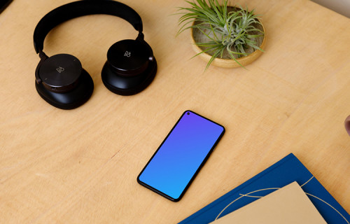 Google Pixel 5 on a table with a pair of headphones at the side