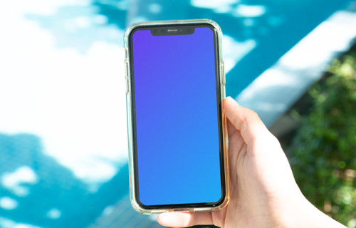 iPhone mockup sostenido por un usuario junto a una piscina