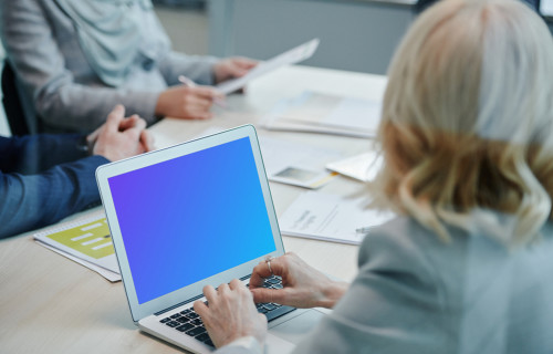 Lady at a conference table using a MacBook Air mockup