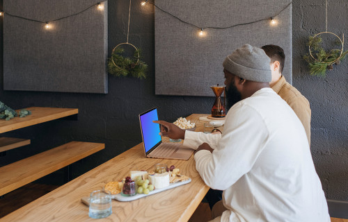 Microsoft Surface Laptop mockup en un restaurante con dos usuarios