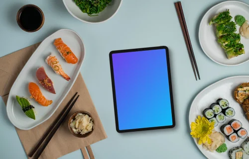 Tablet mockup between plates of sushi