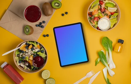 Tablet mockup surrounded by veggie salads and fruits
