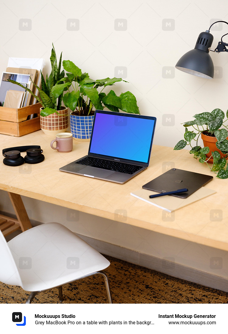Grey MacBook Pro on a table with plants in the background
