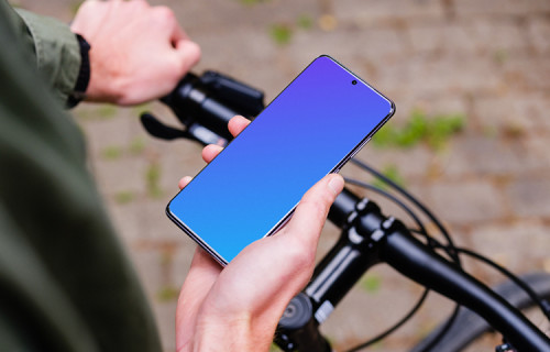 Holding bike in one hand with Samsung S20 mockup in the other