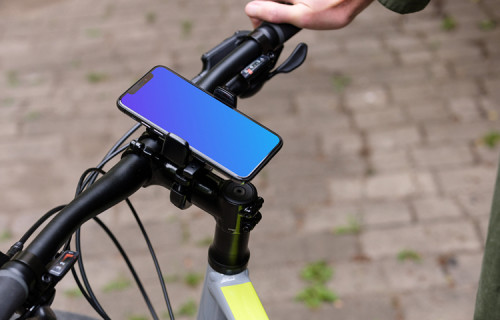 Hombre sentado en una bicicleta con el iPhone 11 Pro mockup en el soporte de la bicicleta