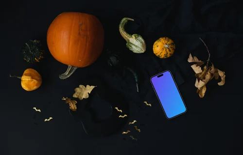 Calabaza de Halloween mockup con un teléfono inteligente en el fondo oscuro