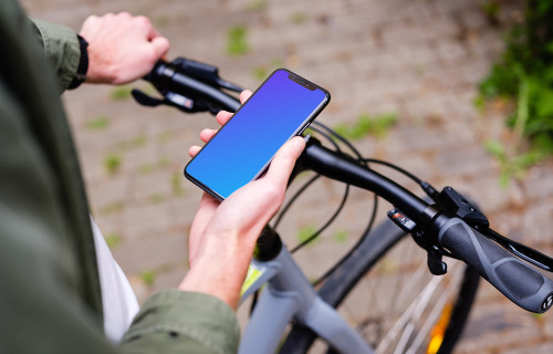 Holding an iPhone 11 Pro mockup while waiting on a bike