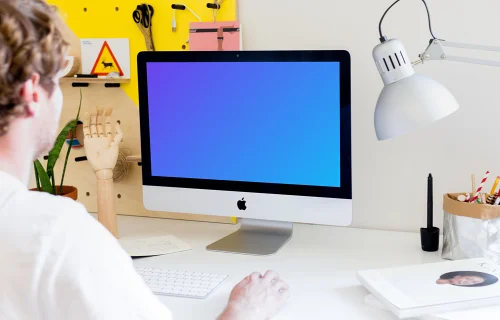 Hombre trabajando en el iMac mockup (vista en ángulo)
