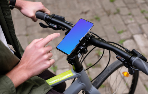 Sentado en la bicicleta golpeando el Samsung S20 mockup en un soporte para bicicletas