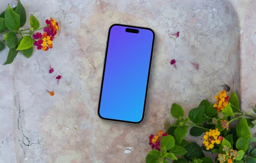 Smartphone mockup on a stone surface with flowers