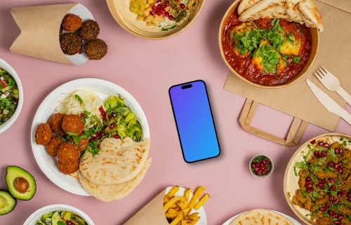 Smartphone mockup surrounded by selection of delicious Middle Eastern dishes