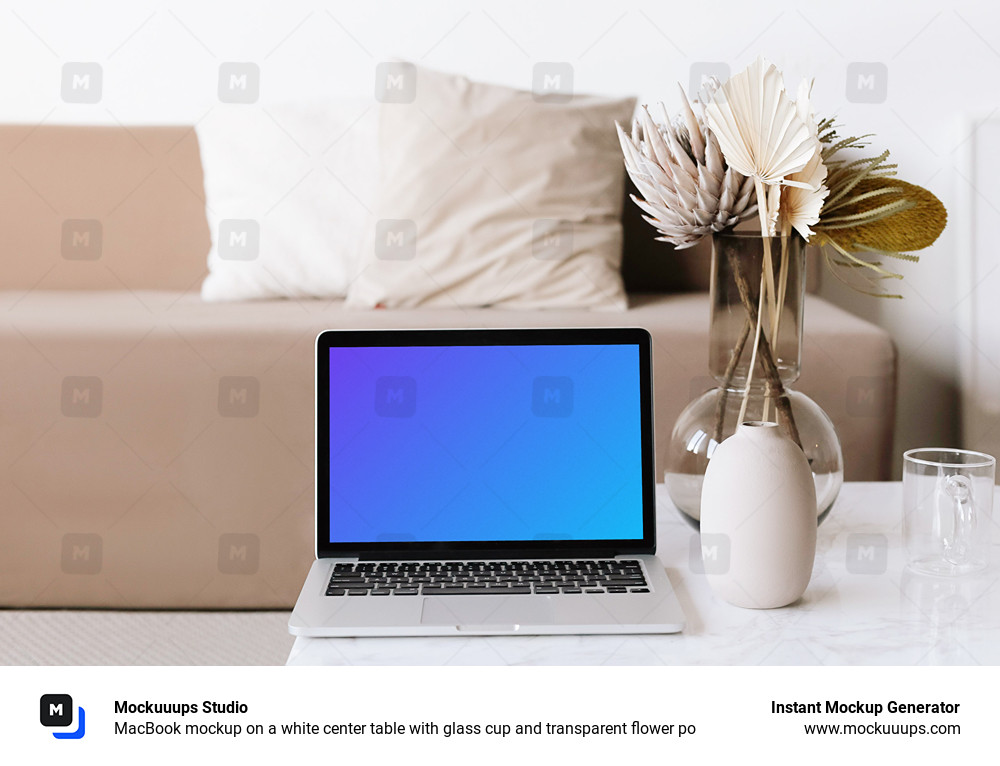 MacBook mockup en una mesa central blanca con vaso de cristal y flor transparente po