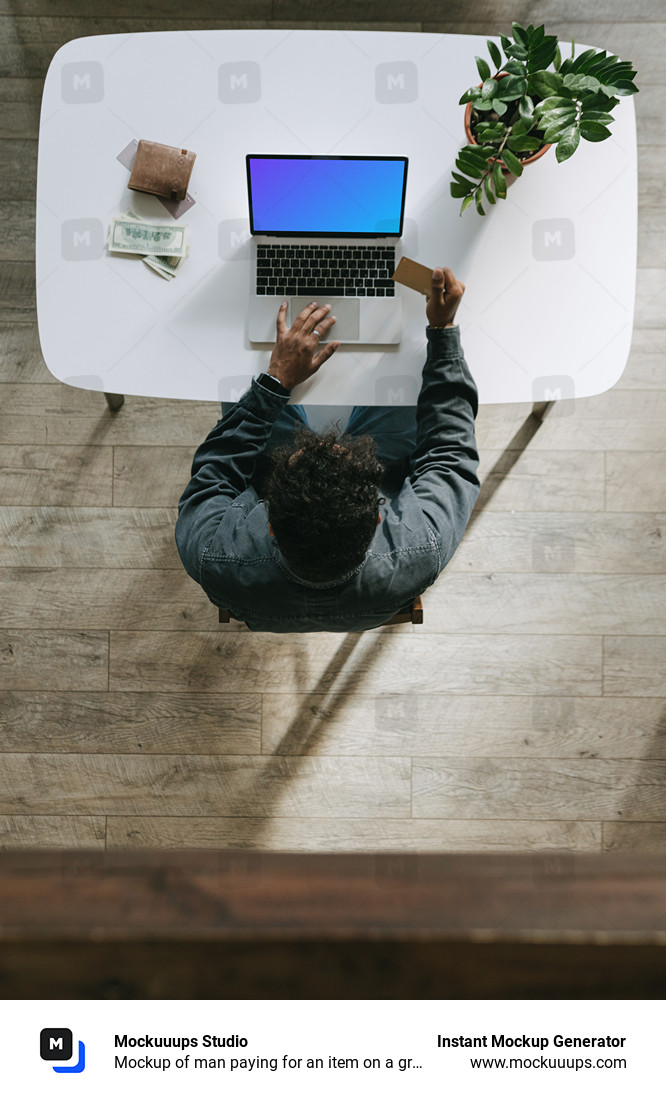 Mockup de un hombre pagando un artículo en un MacBook gris junto a una cartera.