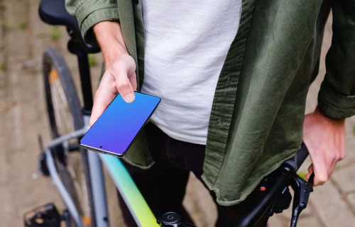 Sosteniendo el Samsung S20 mockup delante de una bicicleta