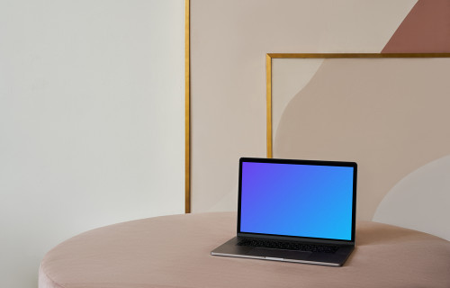 MacBook mockup sobre una mesa con un bonito cuadro detrás
