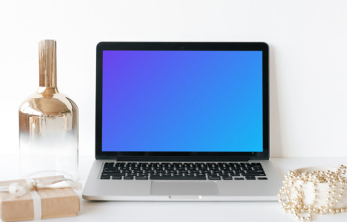 MacBook mockup sobre una mesa blanca con un bote de cristal al lado