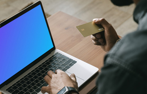 Hombre realizando un pago en línea con una tarjeta Visa en su ordenador MacBook mockup.