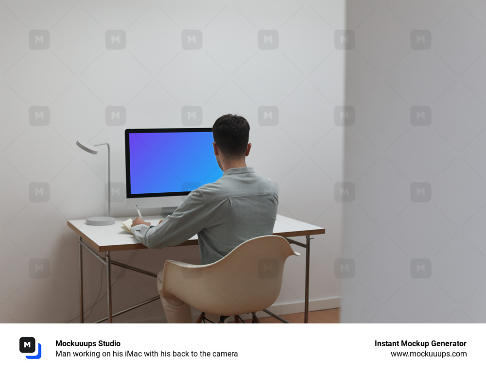 Hombre trabajando en su iMac de espaldas a la cámara