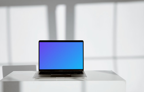 MacBook minimalista mockup sobre una mesa blanca