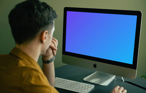 Mockup de usuario mirando su iMac mientras trabaja